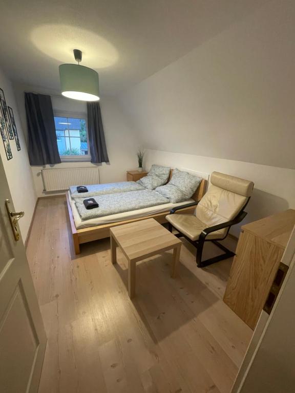 a living room with a bed and a chair at #7 Doppelzimmer mit Gemeinschaftsbad in Memmingen