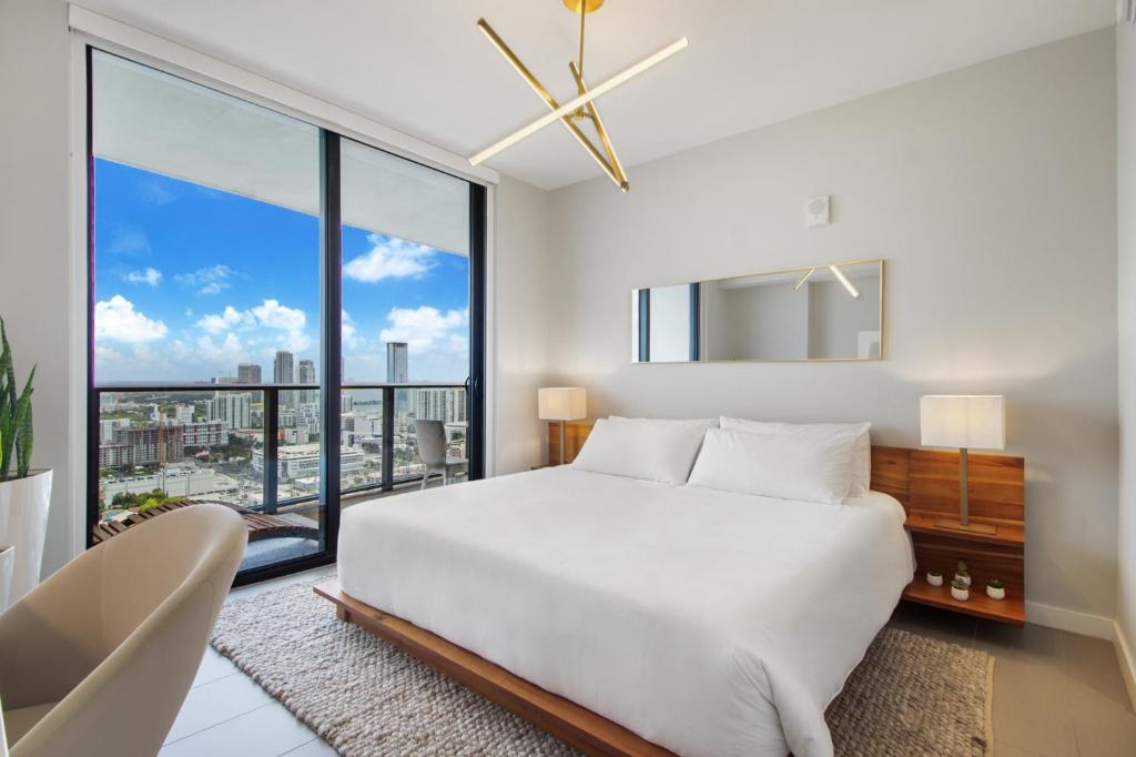 a bedroom with a large white bed and a large window at Lunabase Heavenly View in Miami