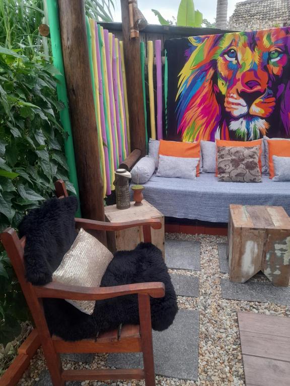 a mural of a lion on a wall with a couch at Cabana Verde Rosa in Barra de Ibiraquera