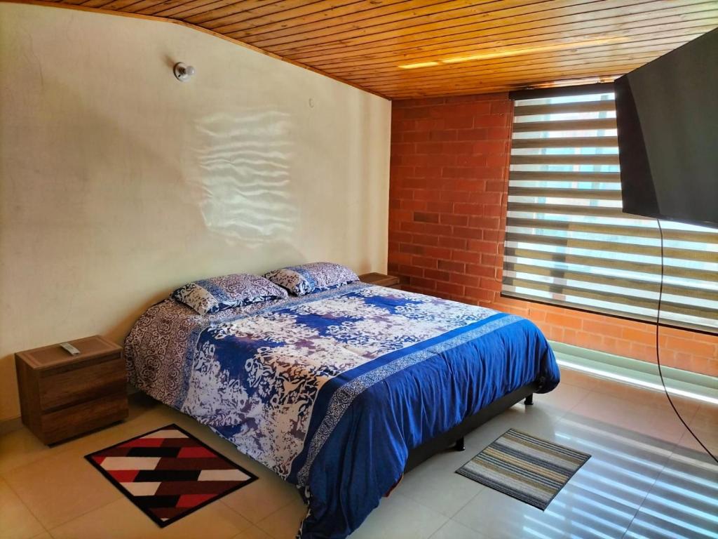 een slaapkamer met een bed in een kamer met een raam bij Casa San Daniel in Paipa