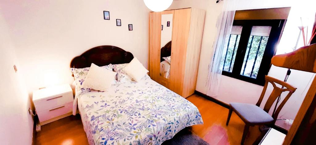 a bedroom with a bed and a chair and a window at HABITACIONES PRIVADAS - CASA RURAL - Baño compartido con los anfitriones in Suances