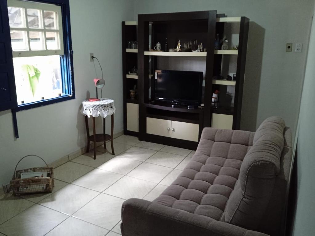 uma sala de estar com um sofá e uma televisão em Casa da tranquilidade em Ouro Preto