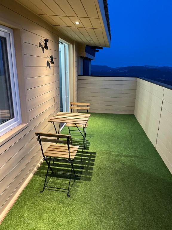 two tables and chairs on a balcony with green grass at La cigale et la fourmie in Le Castellet
