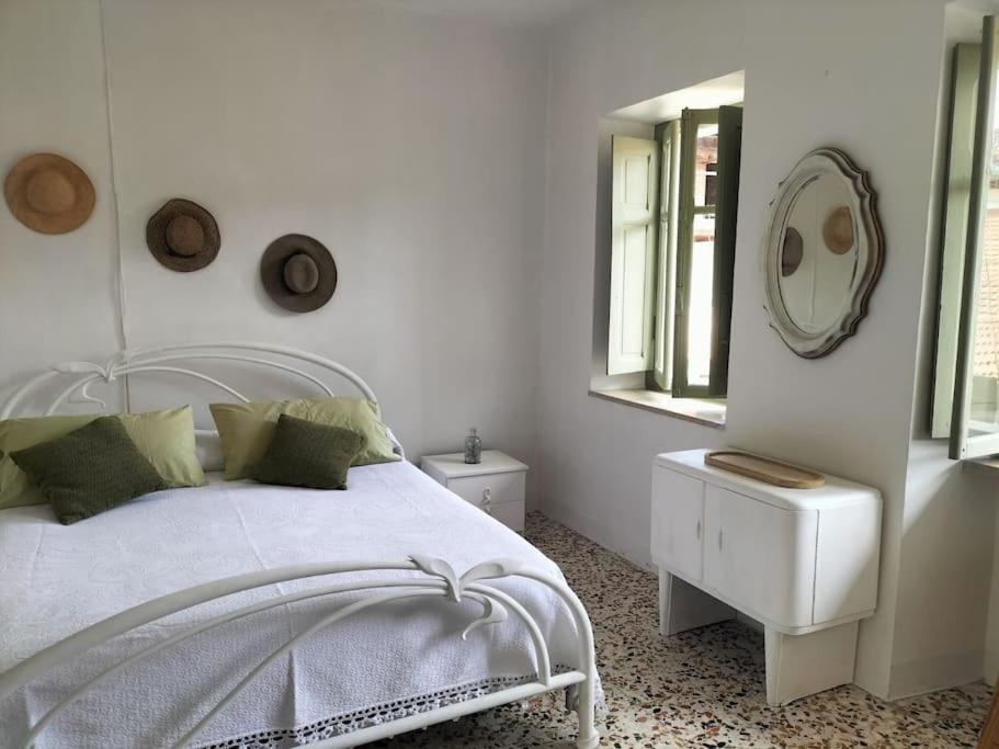 Romantic Casa Rurale Le Masche في Rivara: غرفة نوم بيضاء مع سرير أبيض ومرآة