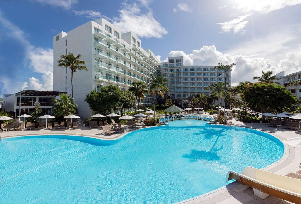 a large swimming pool in front of a hotel at Sonesta Maho Beach All Inclusive Resort Casino & Spa in Maho Reef