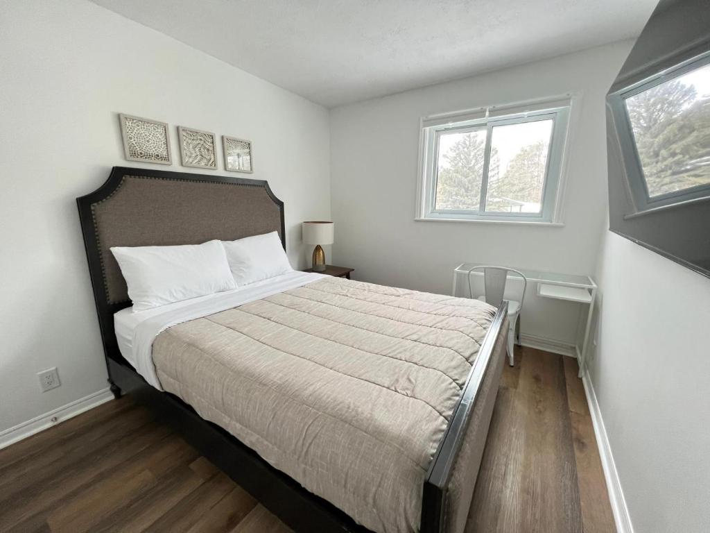 Schlafzimmer mit einem Bett und einem Fenster in der Unterkunft Letitia Heights !C Quiet and Modern Private Bedroom with Shared Bathroom in Barrie