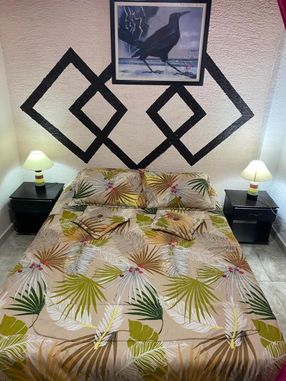a bed in a bedroom with two lamps and a picture at Apartamento Casa Betty Salento. in Salento