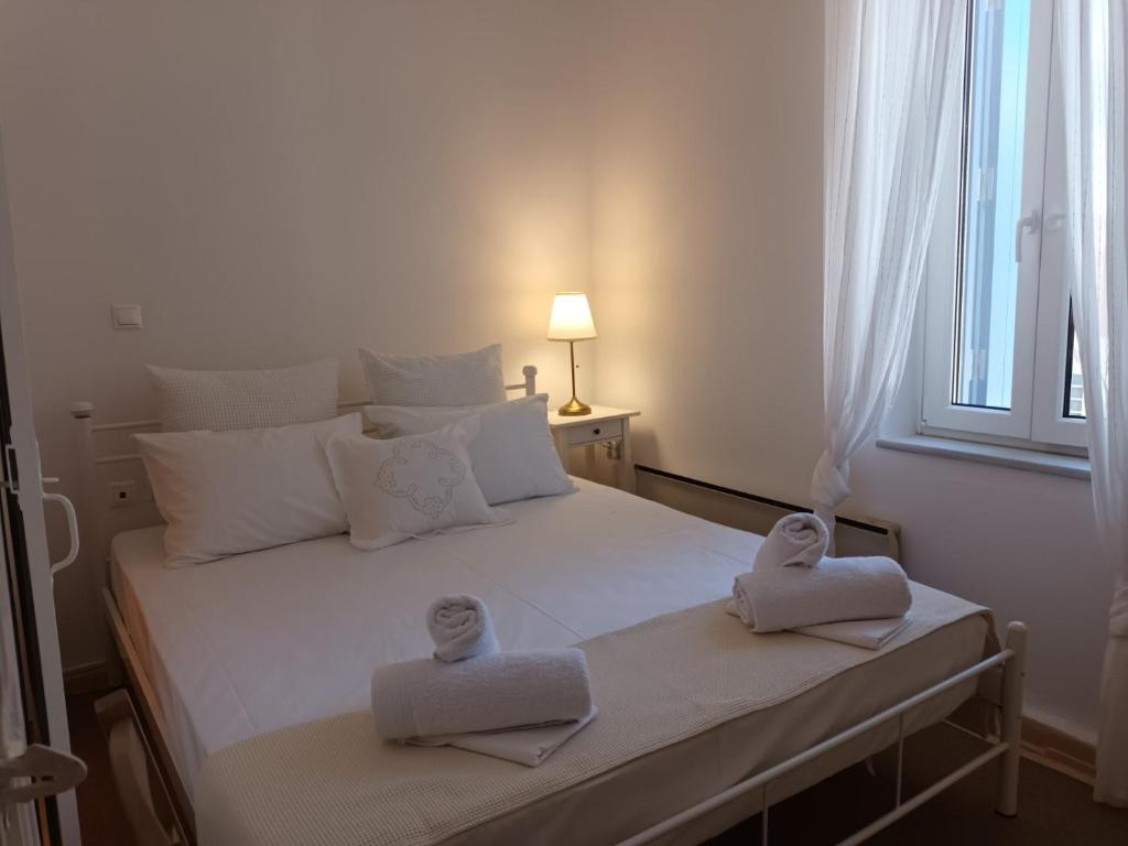 a bedroom with a bed with towels on it at Tenok Boutique Home in Tinos
