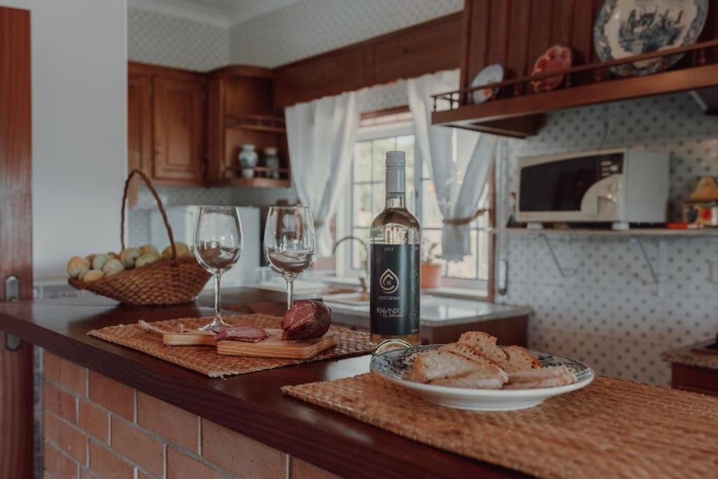 un bancone della cucina con una bottiglia di vino e bicchieri da vino di A Casa do Pereira a Baião
