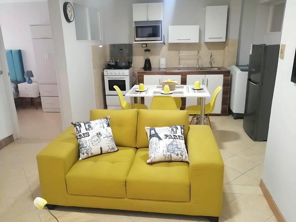 a yellow couch in a kitchen with a table at Jacky's Home Bolognesi in Huaraz