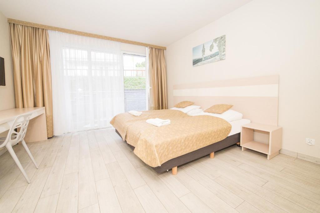 1 dormitorio con cama, escritorio y ventana en VacationClub - Ischgl Apartament 19, en Sienna