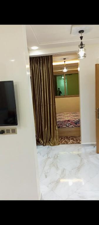 Cette chambre comprend un miroir, un lit et une télévision. dans l'établissement Garçonnière, à Azrou