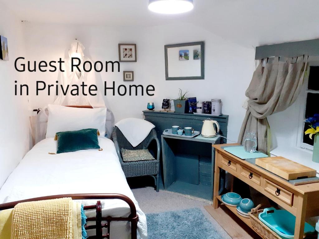 um quarto em casa privada com uma cama e uma secretária em Higher Barton Guest room em Martock