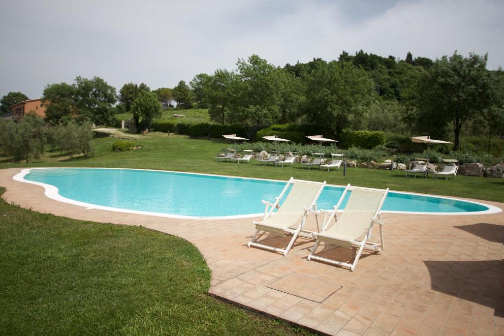 a couple of chairs and a swimming pool at Bio Agriturismo Il Torrione in Saturnia