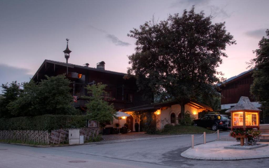 dom z samochodem zaparkowanym przed nim w obiekcie Appartement Pension Bäckenhäusl FERIENWOHNUNGEN Chalets Hütten Komfortzimmer w mieście Uttendorf