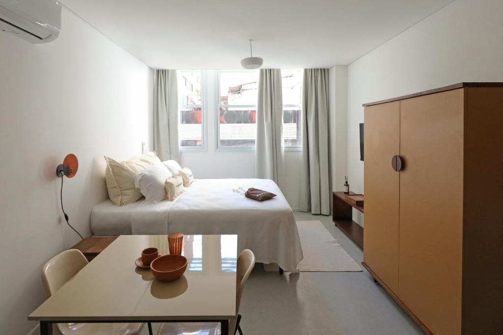 a bedroom with a bed and a table in a room at Tabas - Edifício Arinda - São Paulo in Sao Paulo