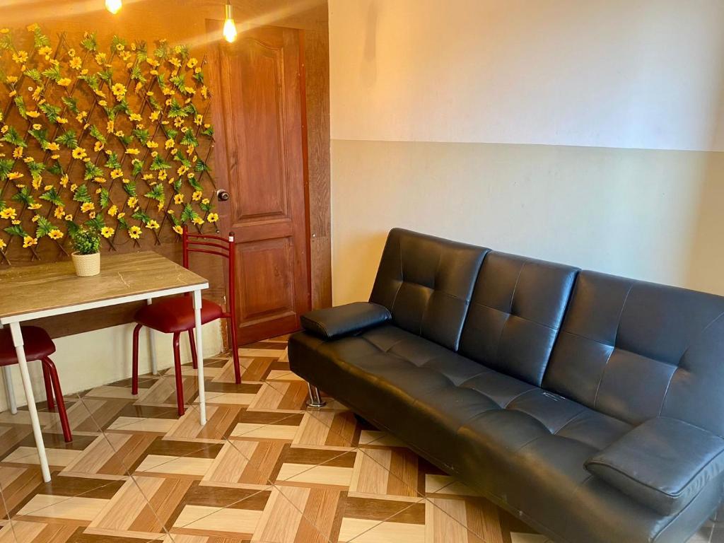 Blue House - cerca del consulado americano في غواياكيل: أريكة من الجلد في غرفة انتظار مع طاولة