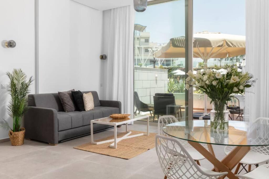 a living room with a couch and a glass table at דירת גן במתחם סי סייד 100 מטר מהים - By Edomlux in Eilat