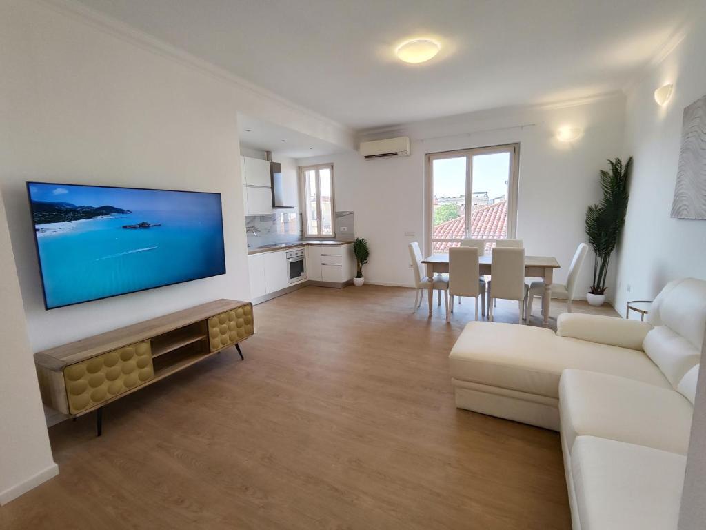 a living room with a couch and a tv on a wall at Attico Vespucci Luxury Penthouse in Olbia