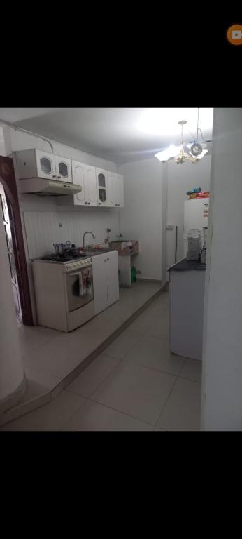 a kitchen with white cabinets and a stove at Apartamento en avenida sexta de Cali in Cali