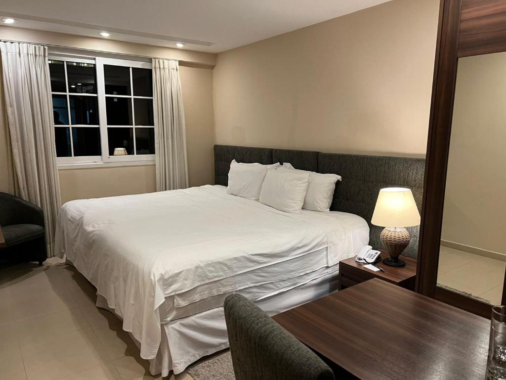 una camera con letto e tavolo con lampada di Exclusiva Suíte Granja Brasil a Petrópolis