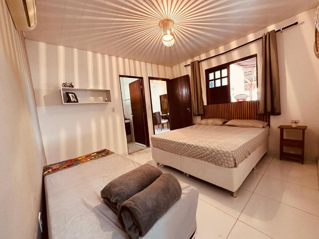 a large bedroom with a bed and a ceiling at Casa Mara Milagres in Passo de Camarajibe