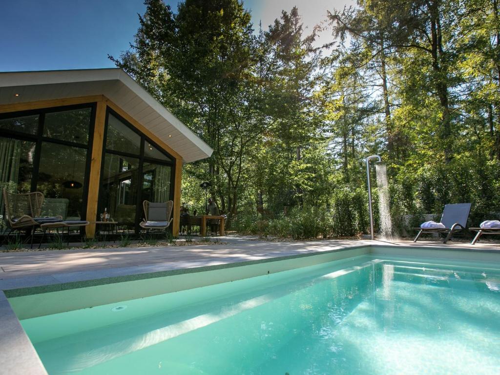 a swimming pool in front of a house at Luxury lodge with private swimming pool, located on a holiday park in Rhenen in Rhenen