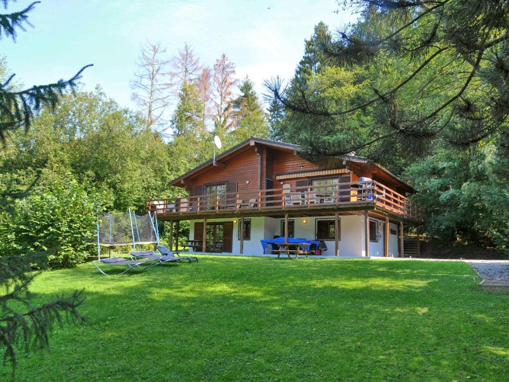 uma casa com um grande quintal em frente em Beautiful wooden chalet with large garden and balcony, located in Barvaux em Barvaux