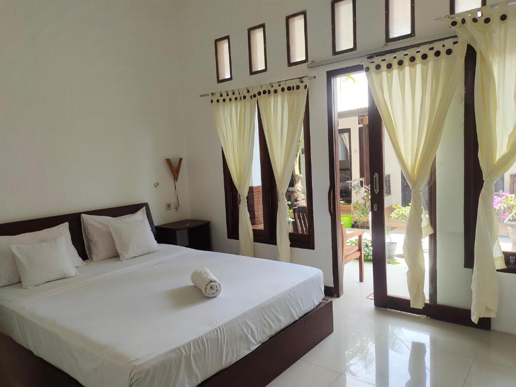 a bedroom with a large white bed with curtains at Vacation Inn Gili in Gili Trawangan