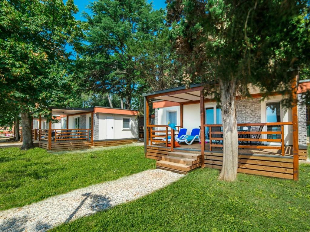 a group of cottages in a yard with a tree at Nice chalet with 2 bathrooms and a dishwasher 15km from Pula in Banjole