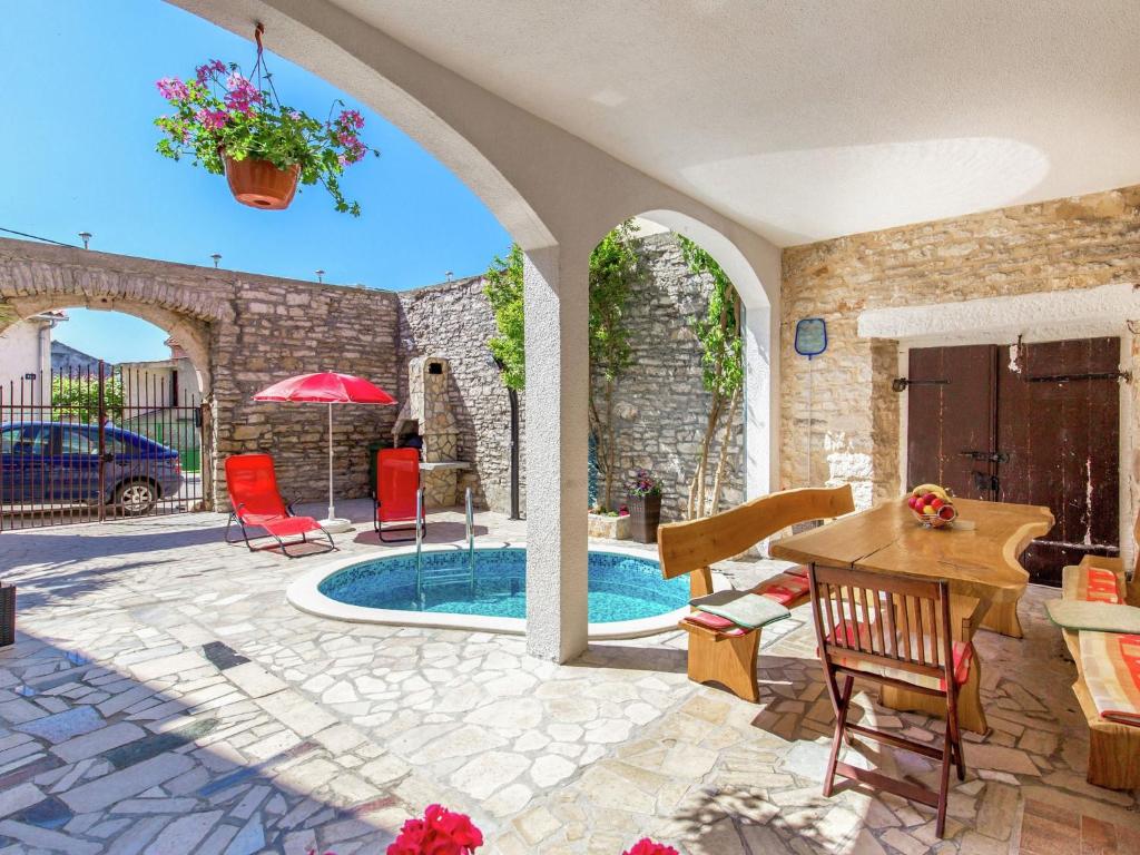 a patio with a table and chairs and a pool at Apartment in Medulin near Sandy Beaches in Medulin