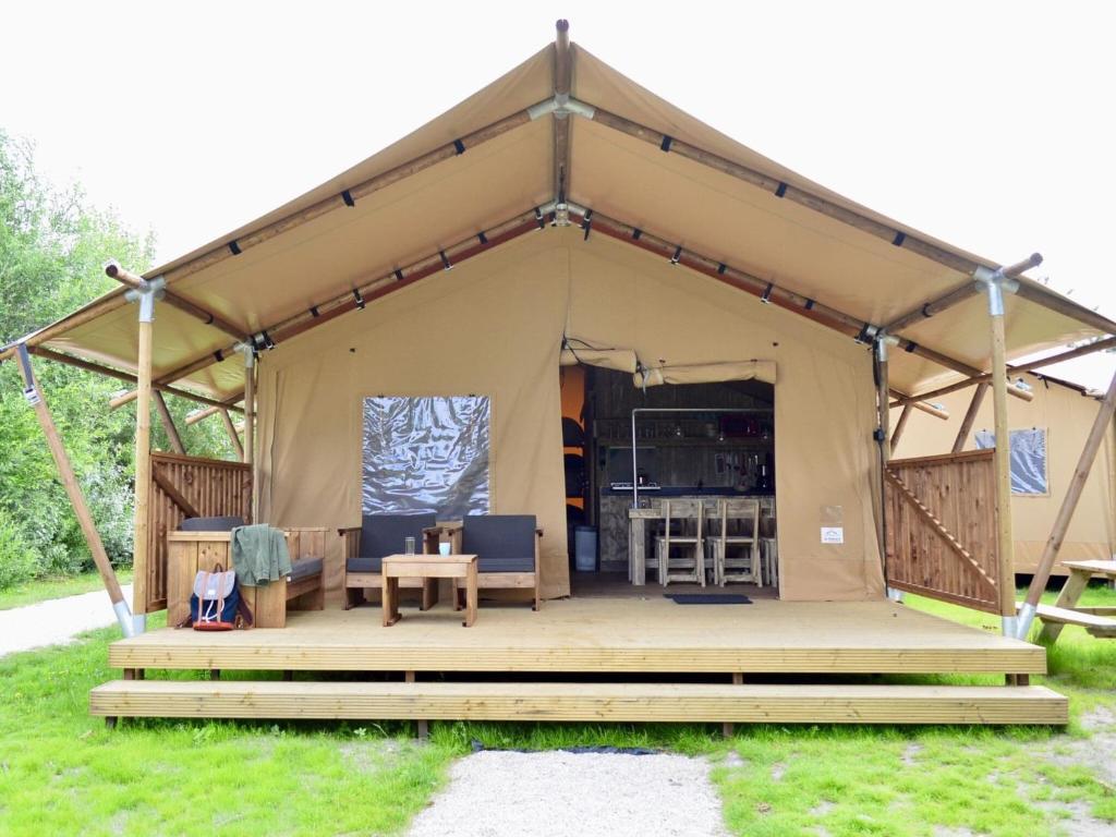a tent with a table and chairs in it at Cozy Coastal Tent Stay in 's-Gravenzande