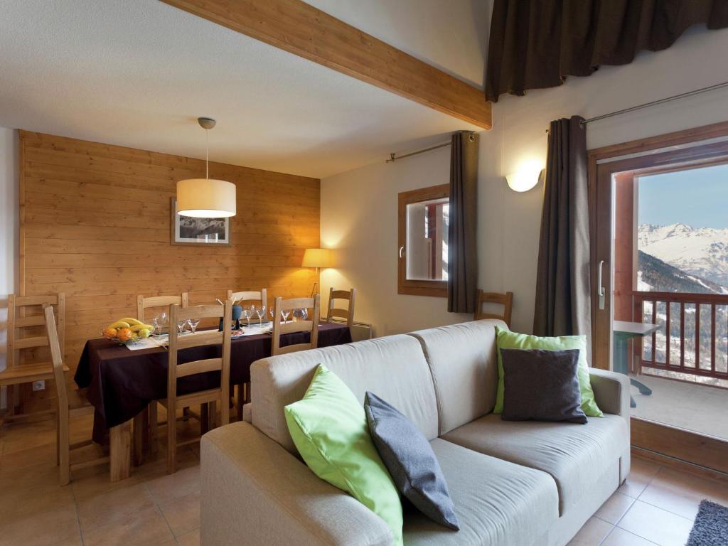 un salon avec un canapé et une salle à manger avec une table dans l'établissement Modern apartment near the ski lift in an authentic village, à Sainte-Foy-Tarentaise