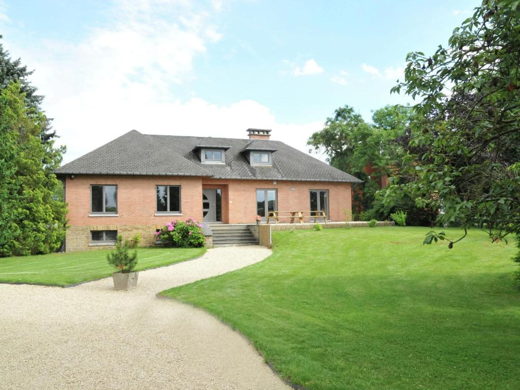 uma grande casa de tijolos com um quintal verde em Comfortable Holiday Home in Marche-en-Famenne with Terrace em Marloie