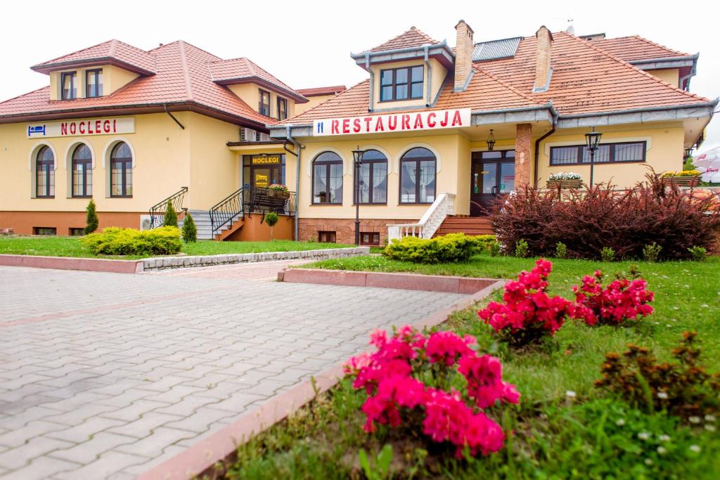 a house with pink flowers in front of it at Noclegi Grill Solo in Sandomierz