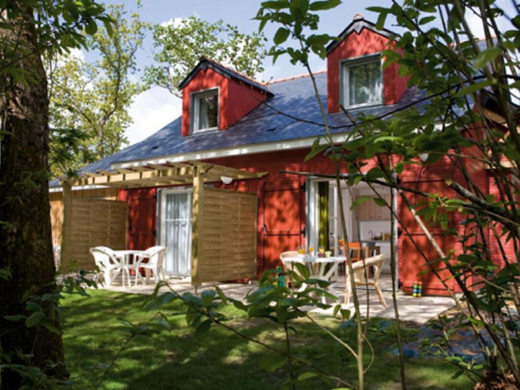 una casa rossa con sedie bianche nel cortile di Beautiful maisonette in a quiet area in the Loire a Saumur