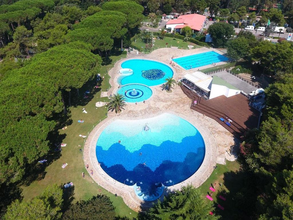 an overhead view of a large swimming pool in a resort at Detached chalet with AC, in a natural park on the coast in Baia Domizia