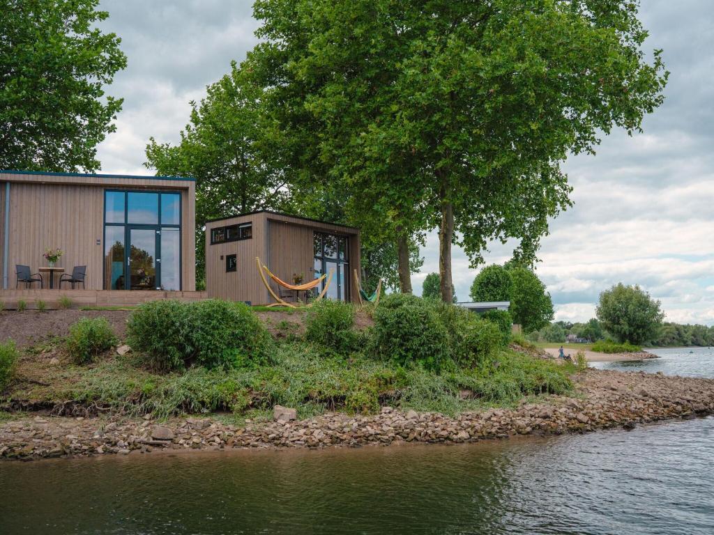 Maurik的住宿－Cozy tiny house on the water, located in a holiday park in the Betuwe，水中岛上的小房子