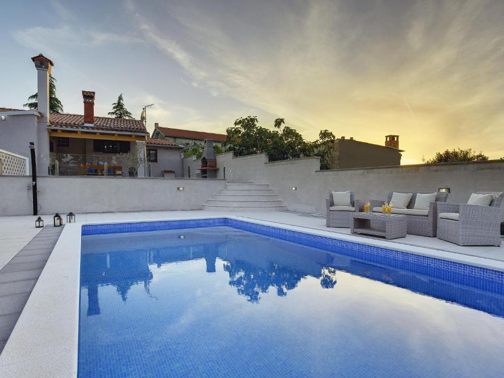 uma piscina com cadeiras e uma casa em Detached house with private pool, 15 minutes drive from the coast em Vodnjan