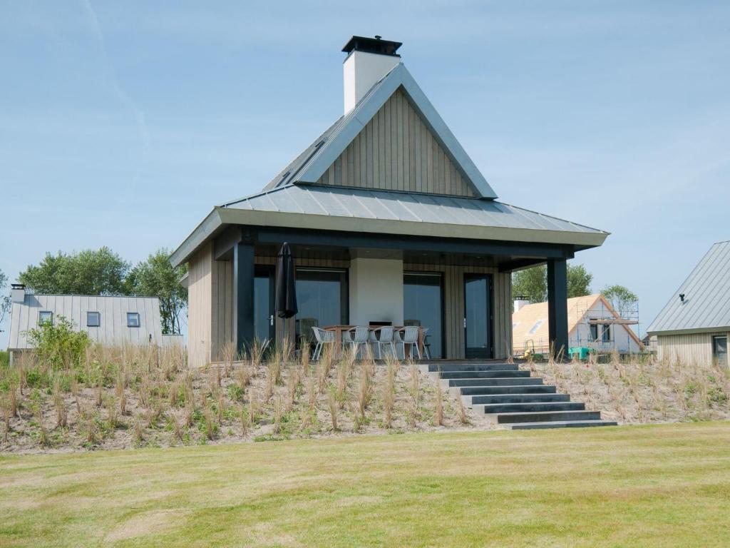 a small house with a pitched roof at Modern design lodge directly at the water, in national park in Tholen
