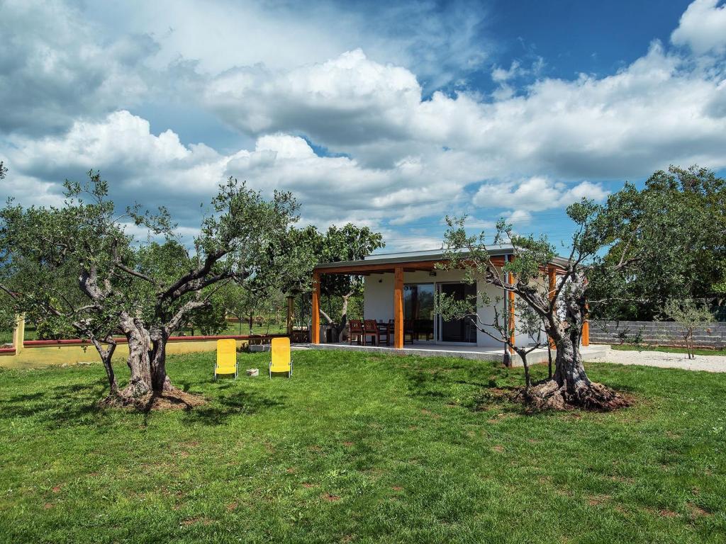 two trees in the grass in front of a building at Modern, detached holiday home with enclosed garden, near the centre and the beach in Fažana