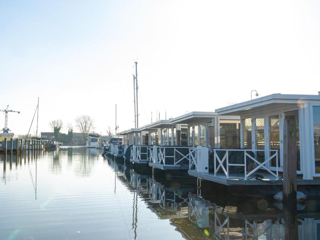 a row of houses on a dock in the water at Lush houseboat with roof terrace in Lemmer in Lemmer