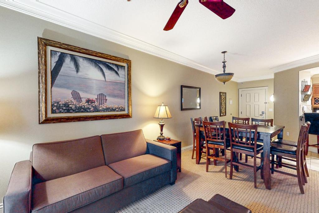 a living room with a couch and a dining room at Emerald Grande W621 in Destin