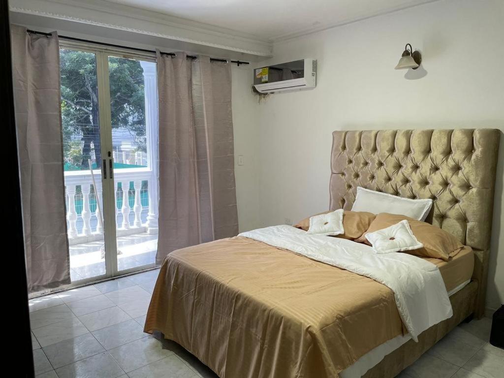 um quarto com uma cama grande e uma janela grande em lotus By Maos em Cartagena das Índias