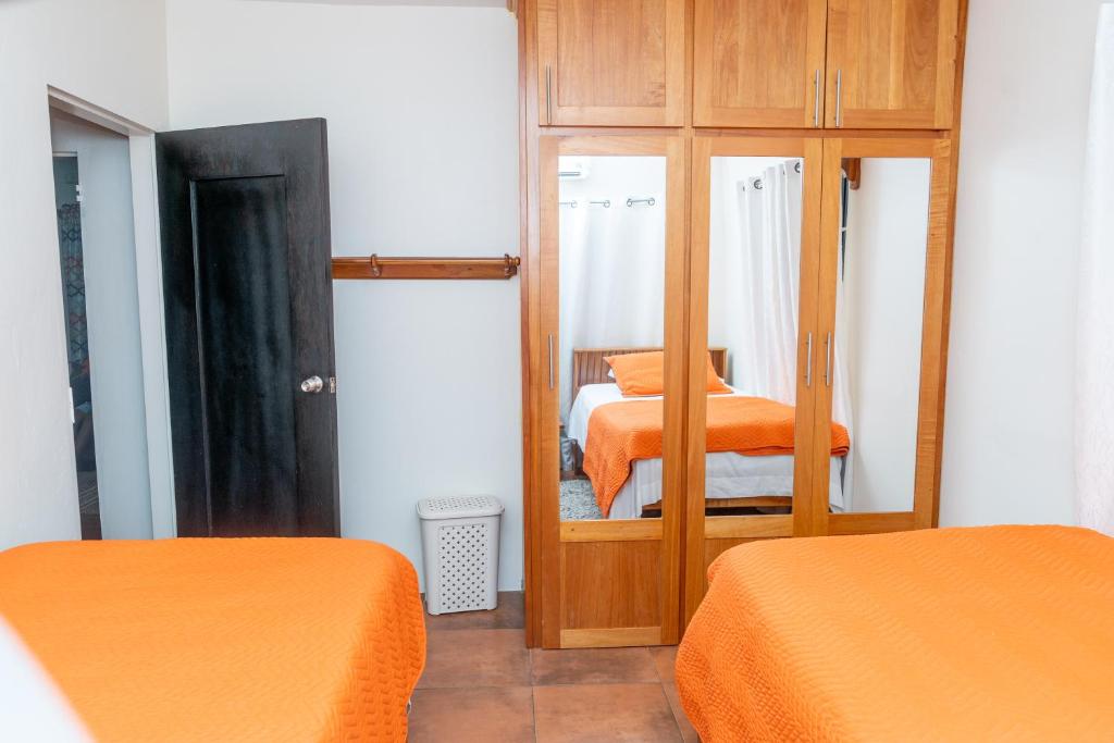 1 dormitorio con 2 camas, espejo y armario en Francis Nook Bourg Mulatresse Room, en San Juan