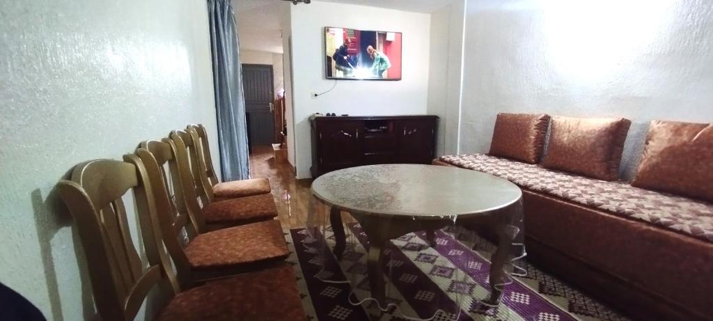 Zimmer mit Sofa, Tisch und Stühlen in der Unterkunft Studio meublé à imouzzer kandar in Imouzzer du Kandar