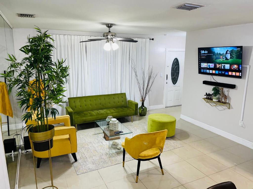 a living room with a green couch and yellow chairs at Cozy Comfy House in Pembroke Pines