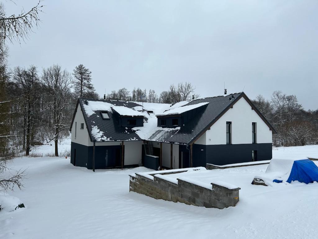 una casa con nieve en el techo en la nieve en Dolní Morava- Apartmán v Prostření Lipce, en Králíky