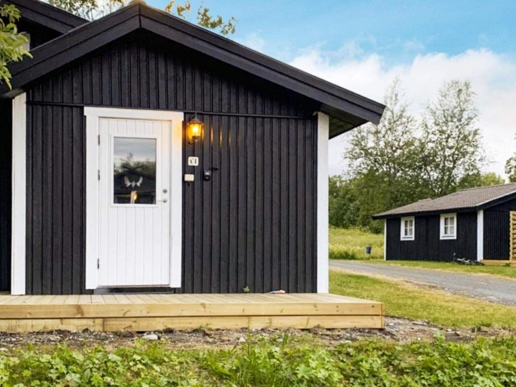 a black and white shed with a white door at Holiday home JÄRPEN II in Järpen