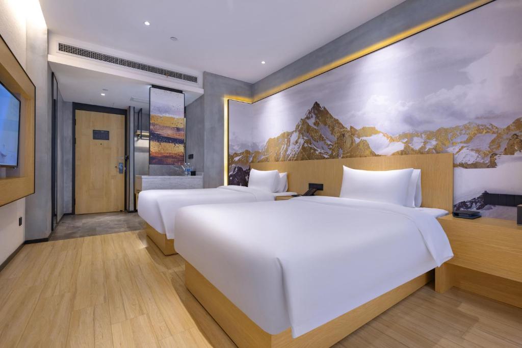 a hotel room with two beds and a painting on the wall at Tuke China Hotel -Wenzhou South Bus Terminal in Wenzhou